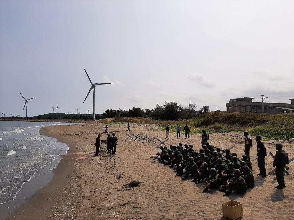 Taiwanische Soldaten haben sich am Strand versammelt und sitzen auf dem Sand