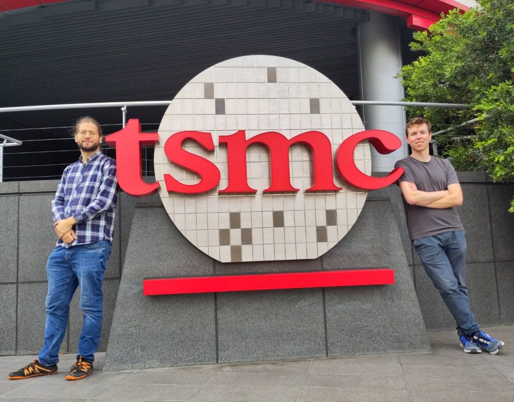 Lukas und Daniel lehnen sich an ein riesiges TSMC-Logo vor dem Museum in Hsinchu