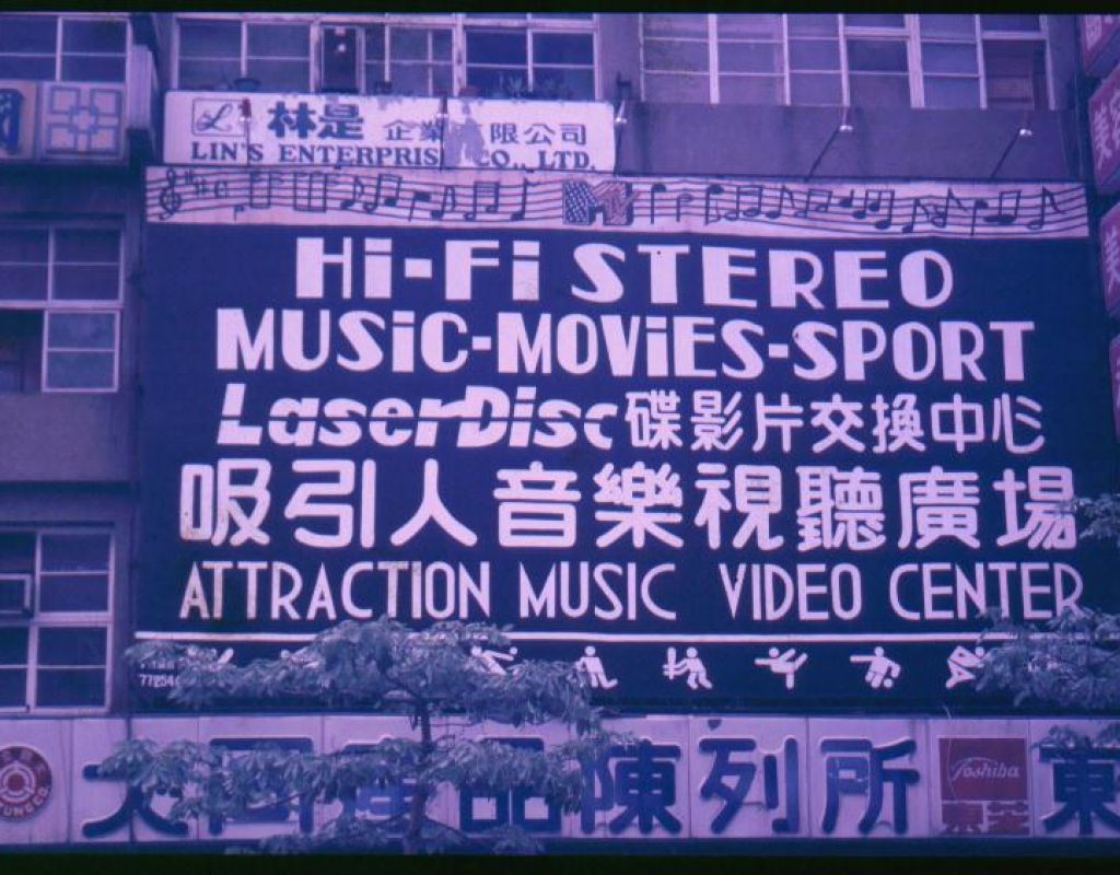 Über zwei Stockwerke an einer Fassade zieht sich ein riesiges Werbeplaket für ein MTV mit der Aufschrift: Attraction Music Video Center